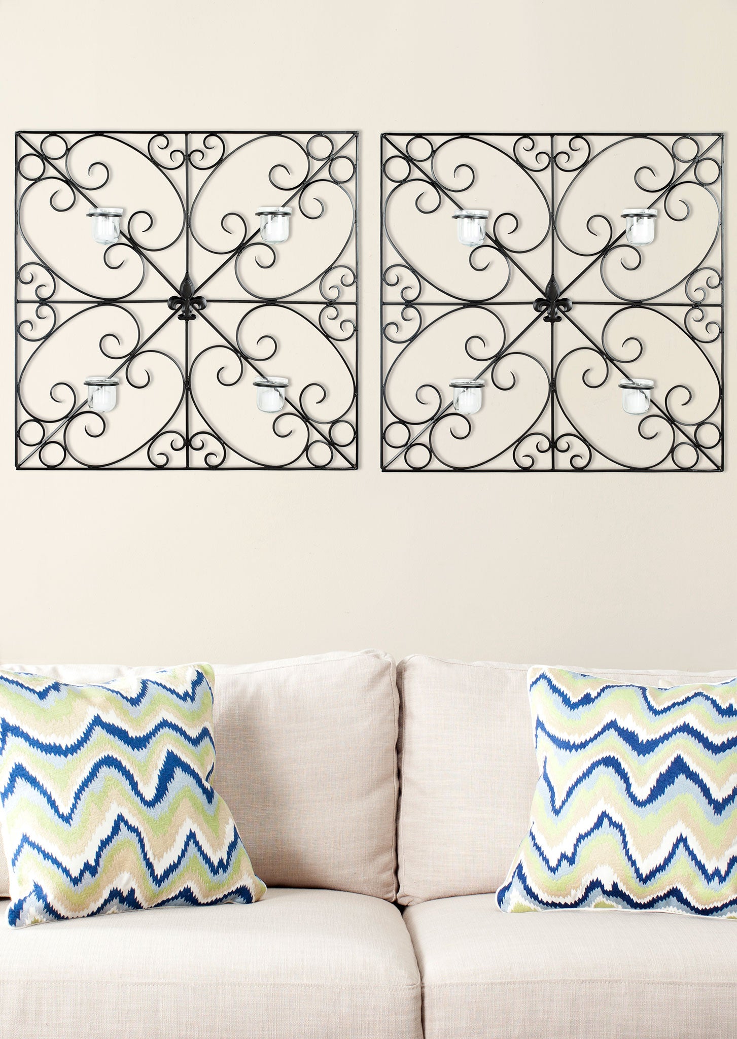 Two ornate black iron wall accents pair scrolling frames with four glass votives apiece. || WDC1005A || front_room