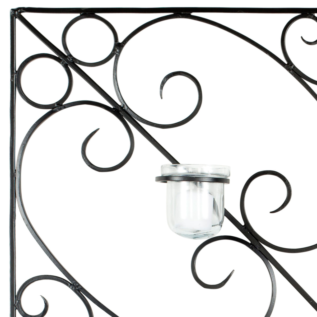Curving black iron scrolls frame a clear glass votive cup with delicate metal detailing. || WDC1005A || detail_studio