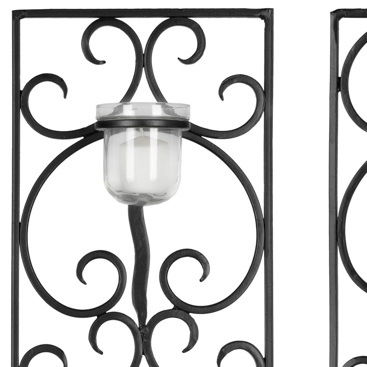 A clear glass votive cup sits amid curling black iron scrollwork and a sturdy square frame.