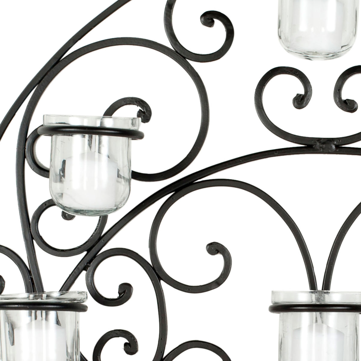 Curving black iron scrollwork frames clear glass votive holders