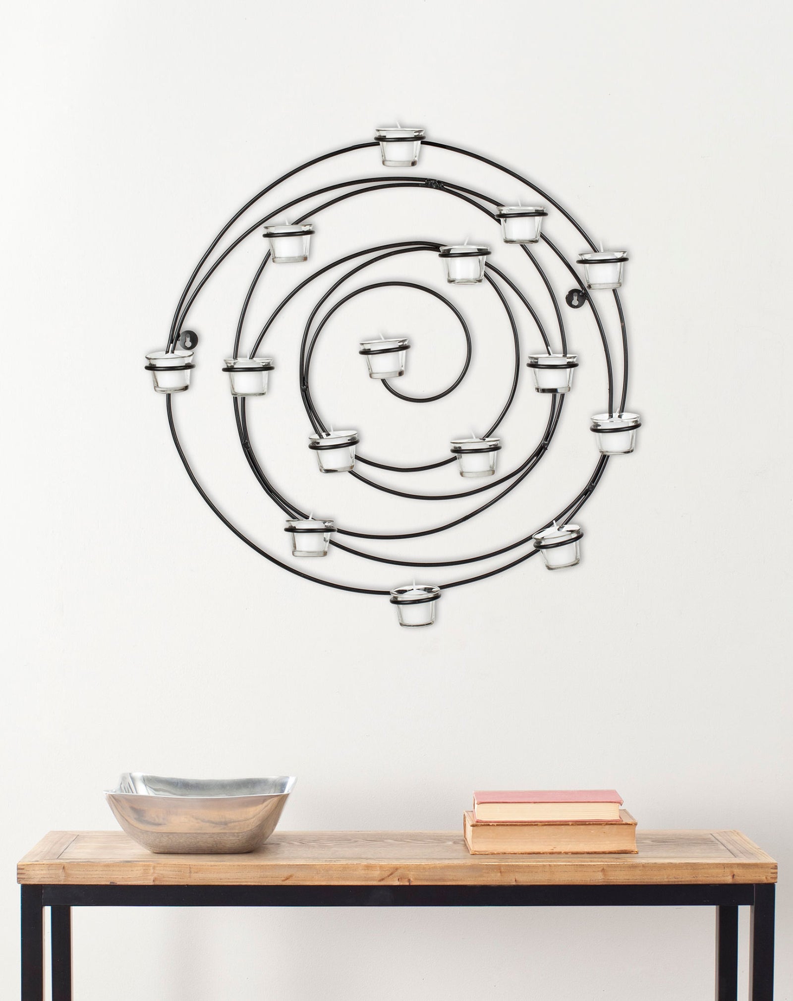 A sculptural spiral of black iron and glass votive holders adds dimension to a wall || WDC1011A || front_room