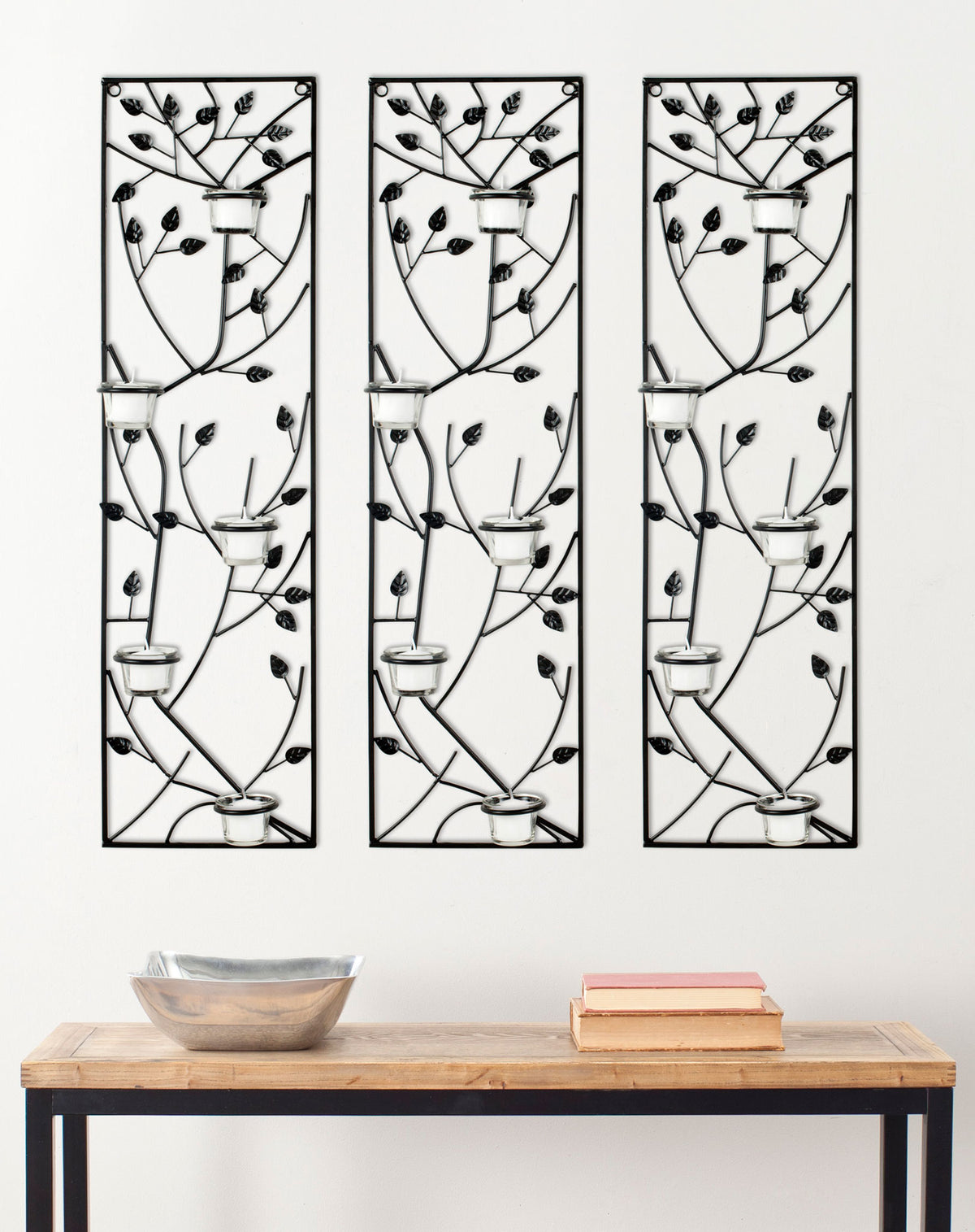 Three black iron leaf panels with glass votive holders create a striking accent above a console table || WDC1013A || front_multi_room