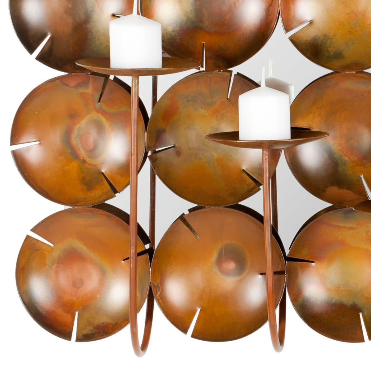 Mottled copper discs contrast with slender candleholders and white pillar candles.