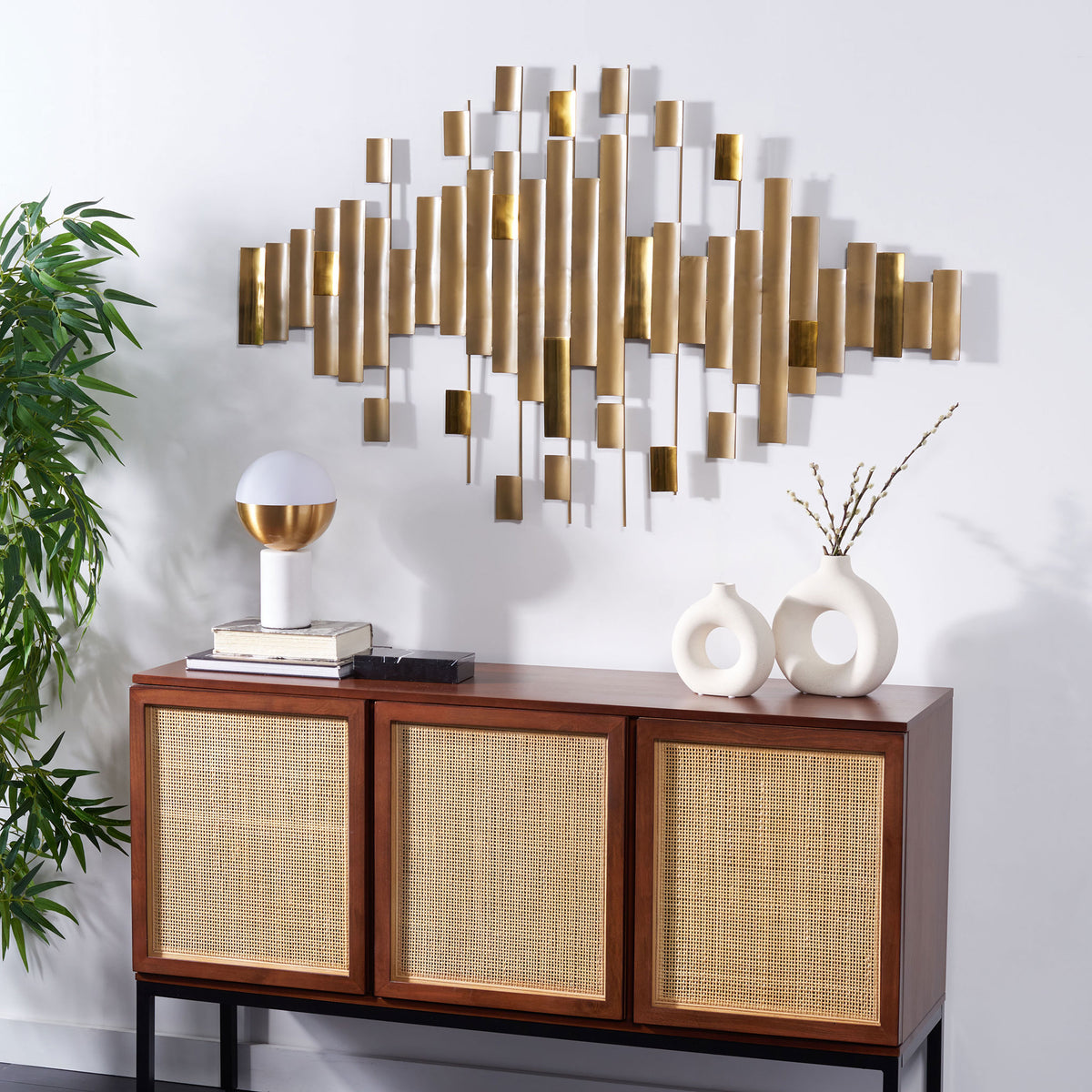 Openwork antique brass wall sculpture brings warm metallic texture above a woven-door console || WDC1029A || front_room