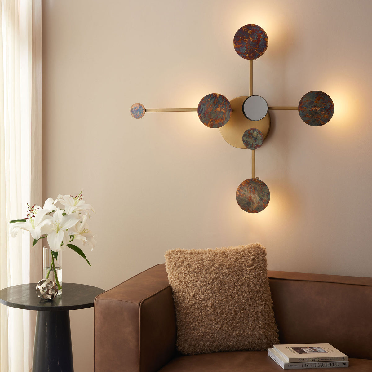 Warm light glows behind textured circular accents, adding ambience to the brass wall decor.