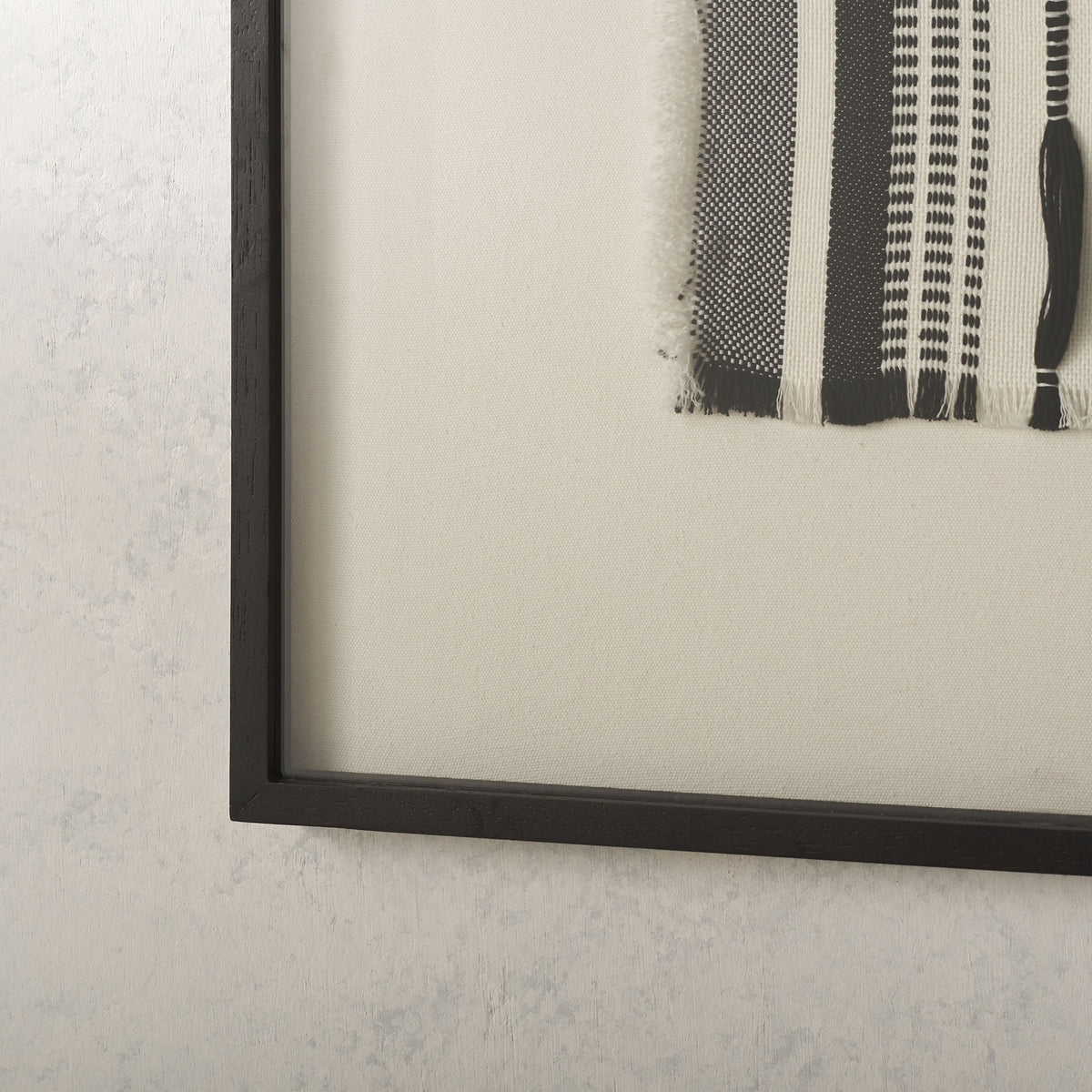 A slim black frame and wide white border highlight the textured monochrome weave. || WLA1900A || detail_room