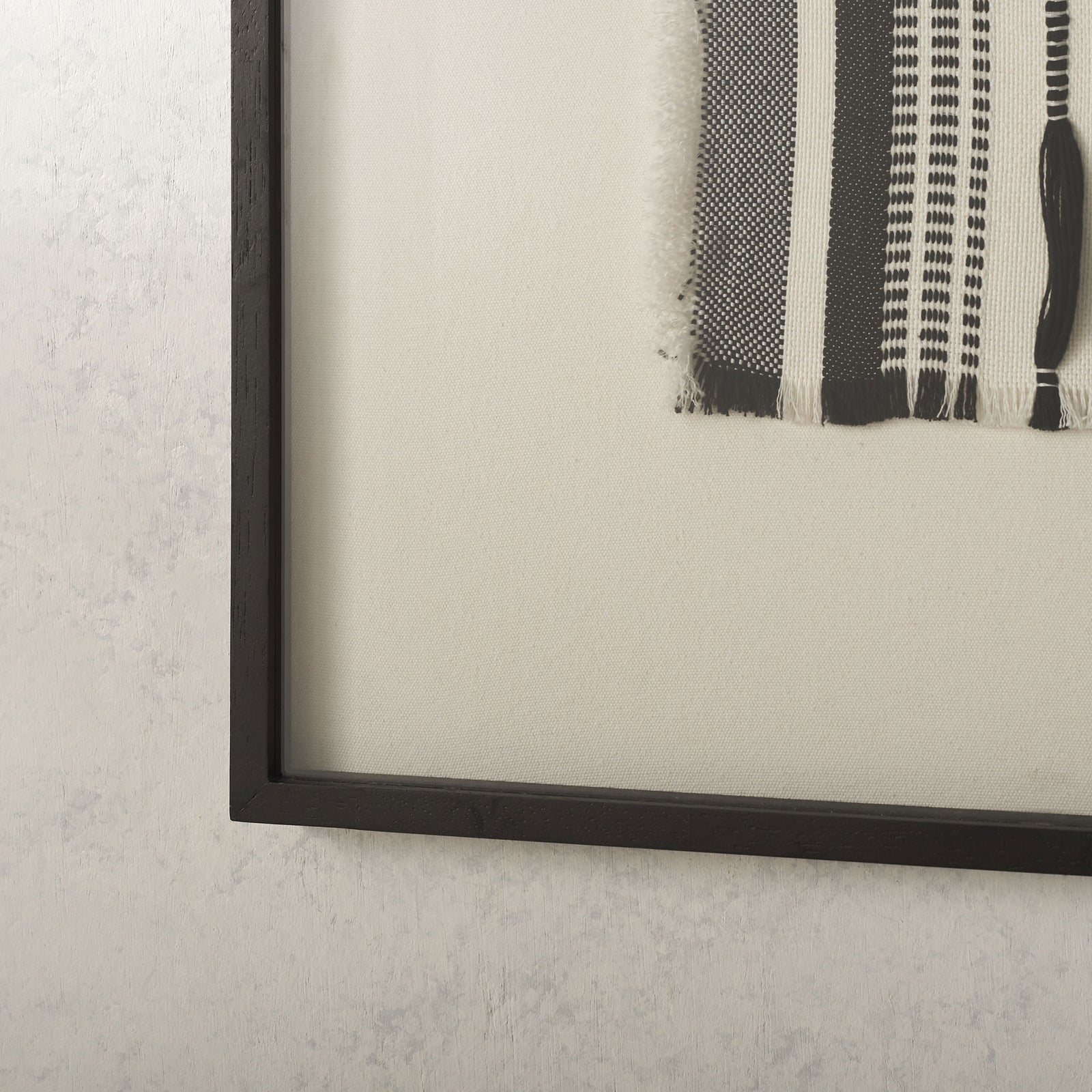 A slim black frame and wide white border highlight the textured monochrome weave. || WLA1900A || detail_room