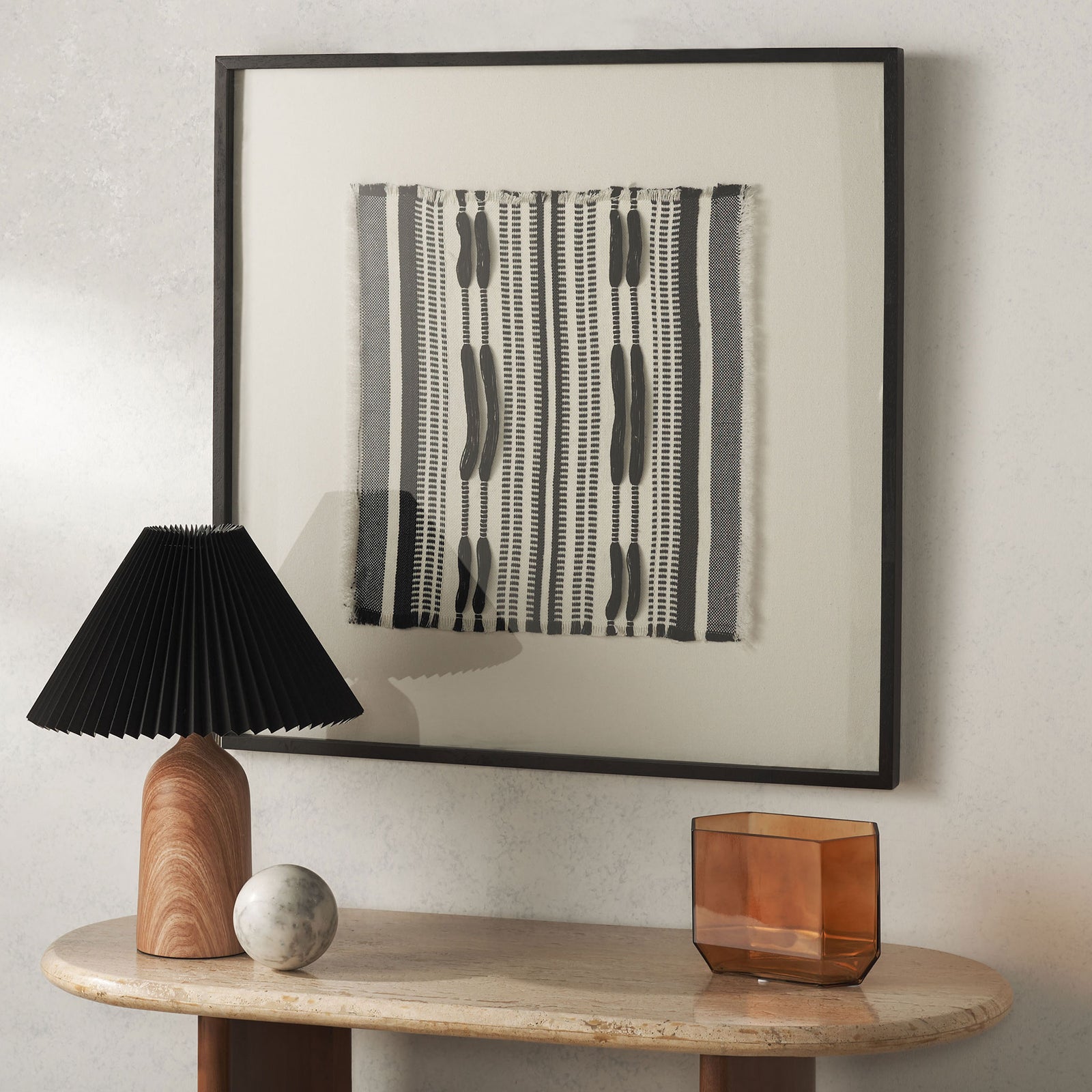 Striped textile art stands out within a wide white border and square black frame. || WLA1900A || front_room