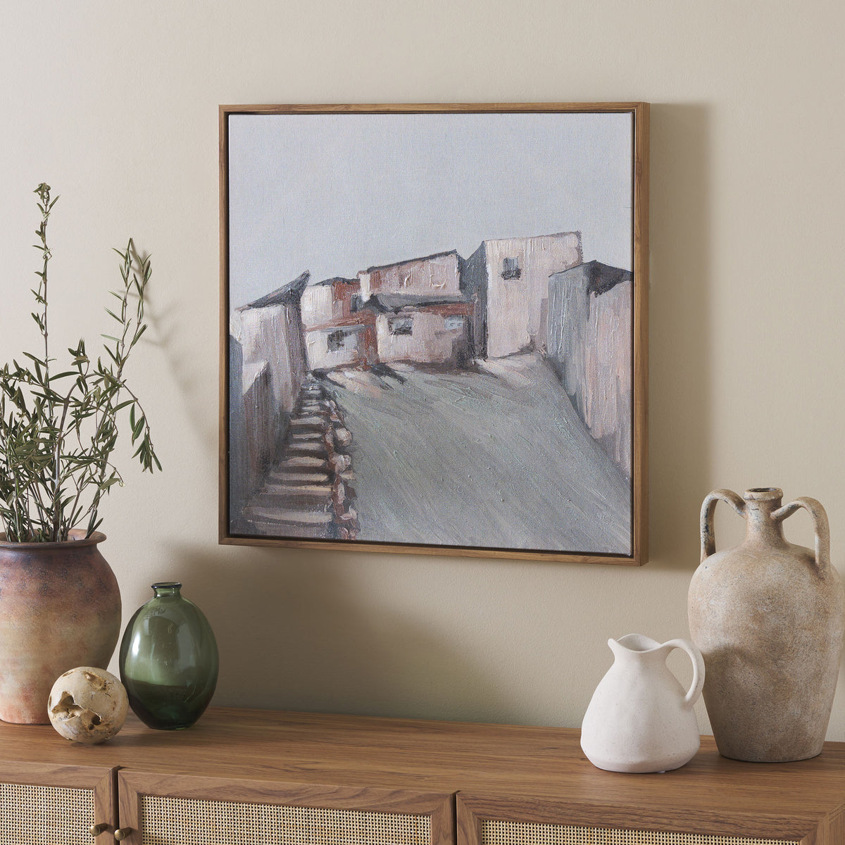 Soft blue and earthy hues in this framed village canvas complement warm wood and natural decor. || WLA3021A || front_room