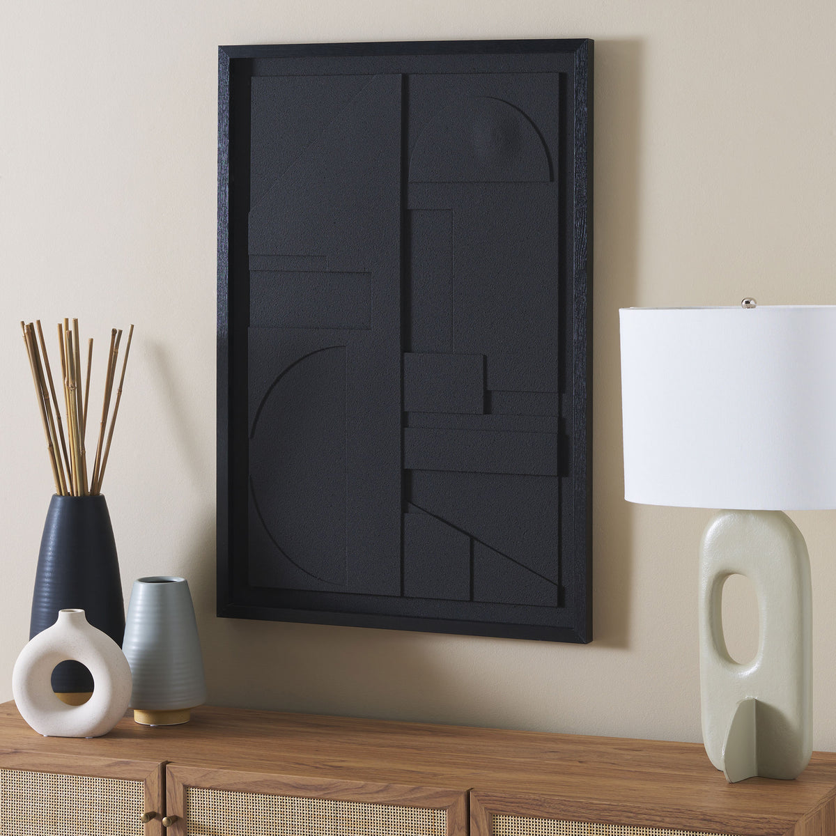 Dimensional black geometric art adds sculptural texture above a wood cabinet. || WLA3023A || front_angle_room
