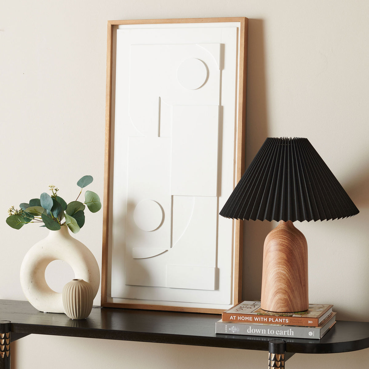 White geometric relief in a light wood frame adds sculptural texture to a dark console || WLA9002A || front_angle_room