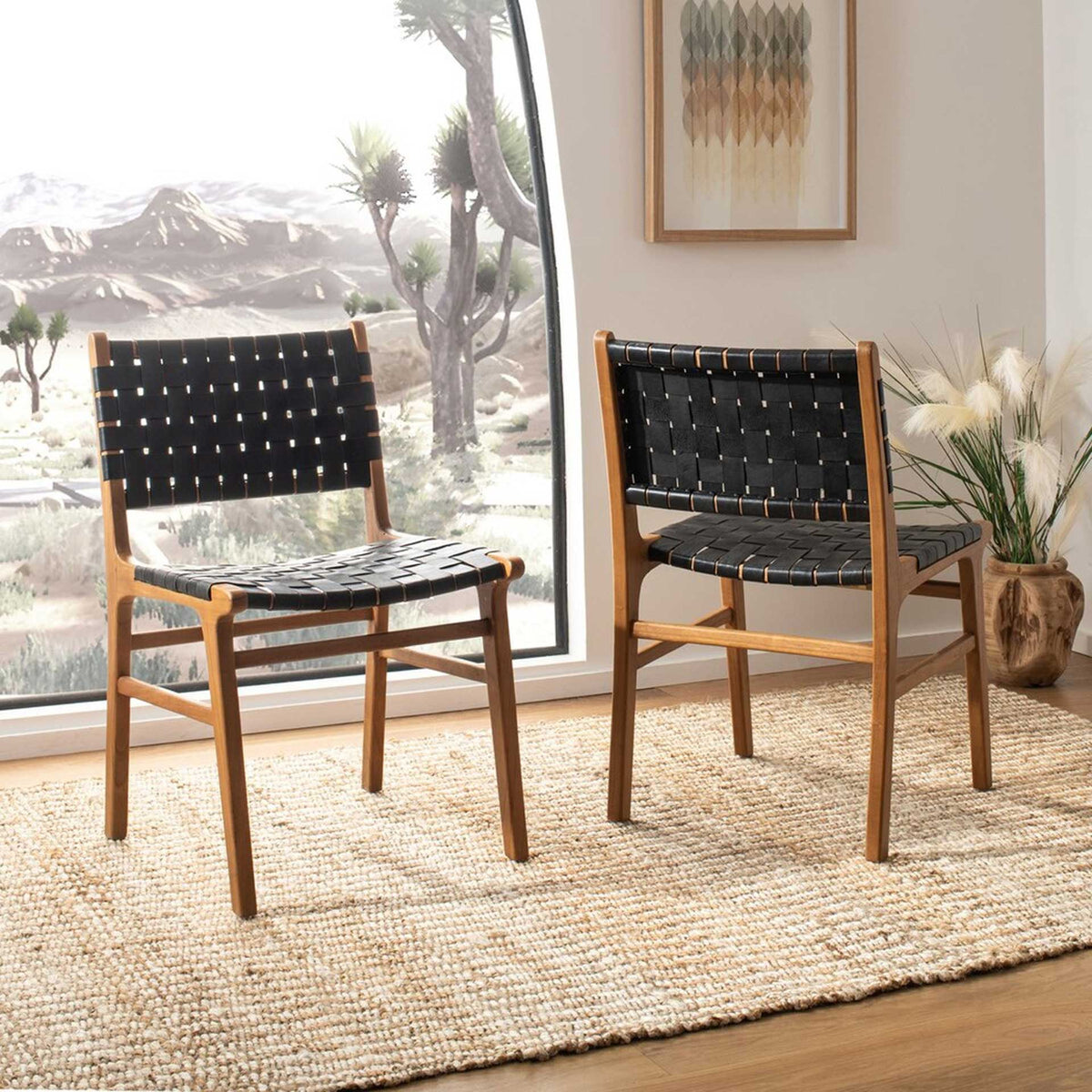 Two woven black leather dining chairs bring warm wood and graphic texture to the room