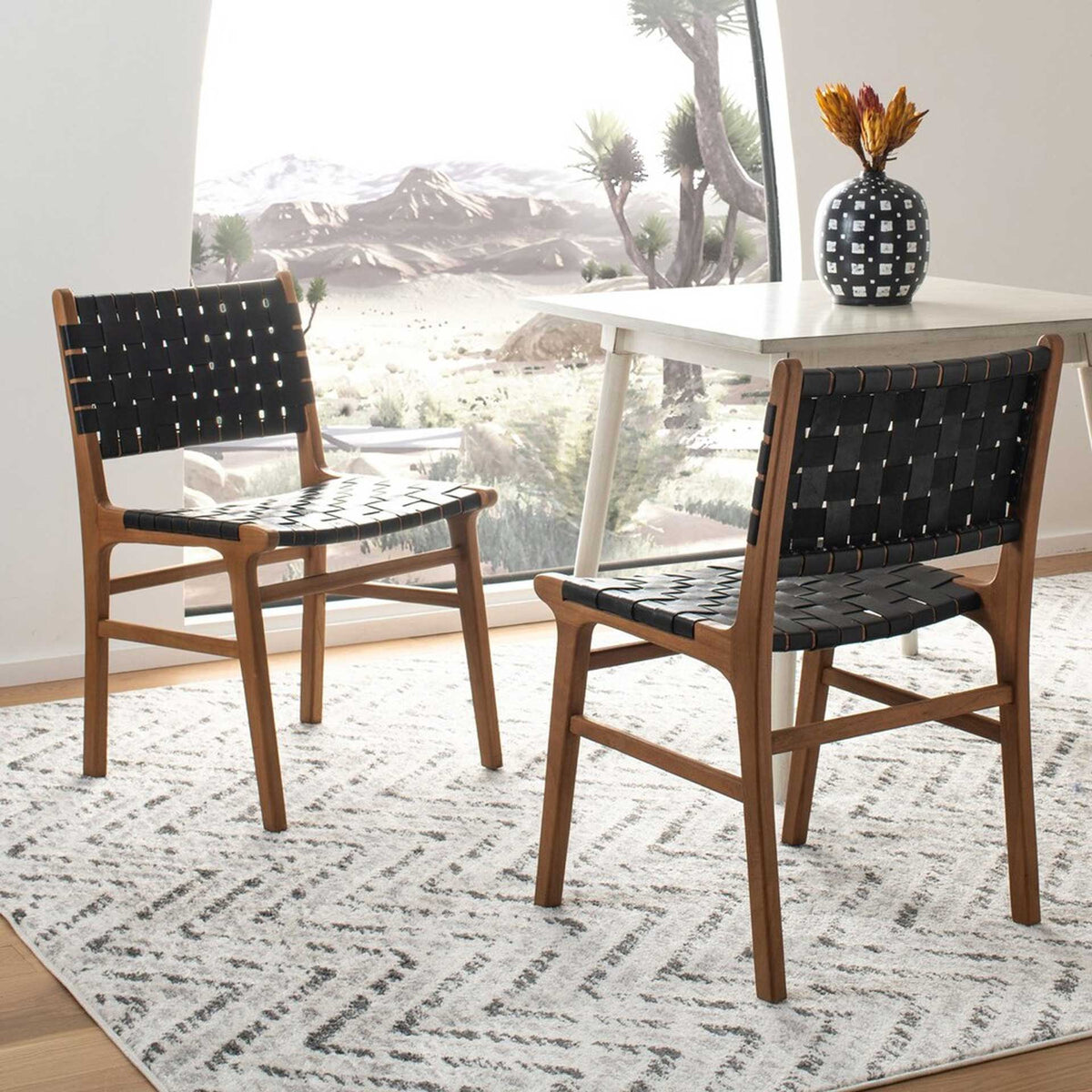 A coordinated chair pair combines black leather weaving with slender wood frames by the table