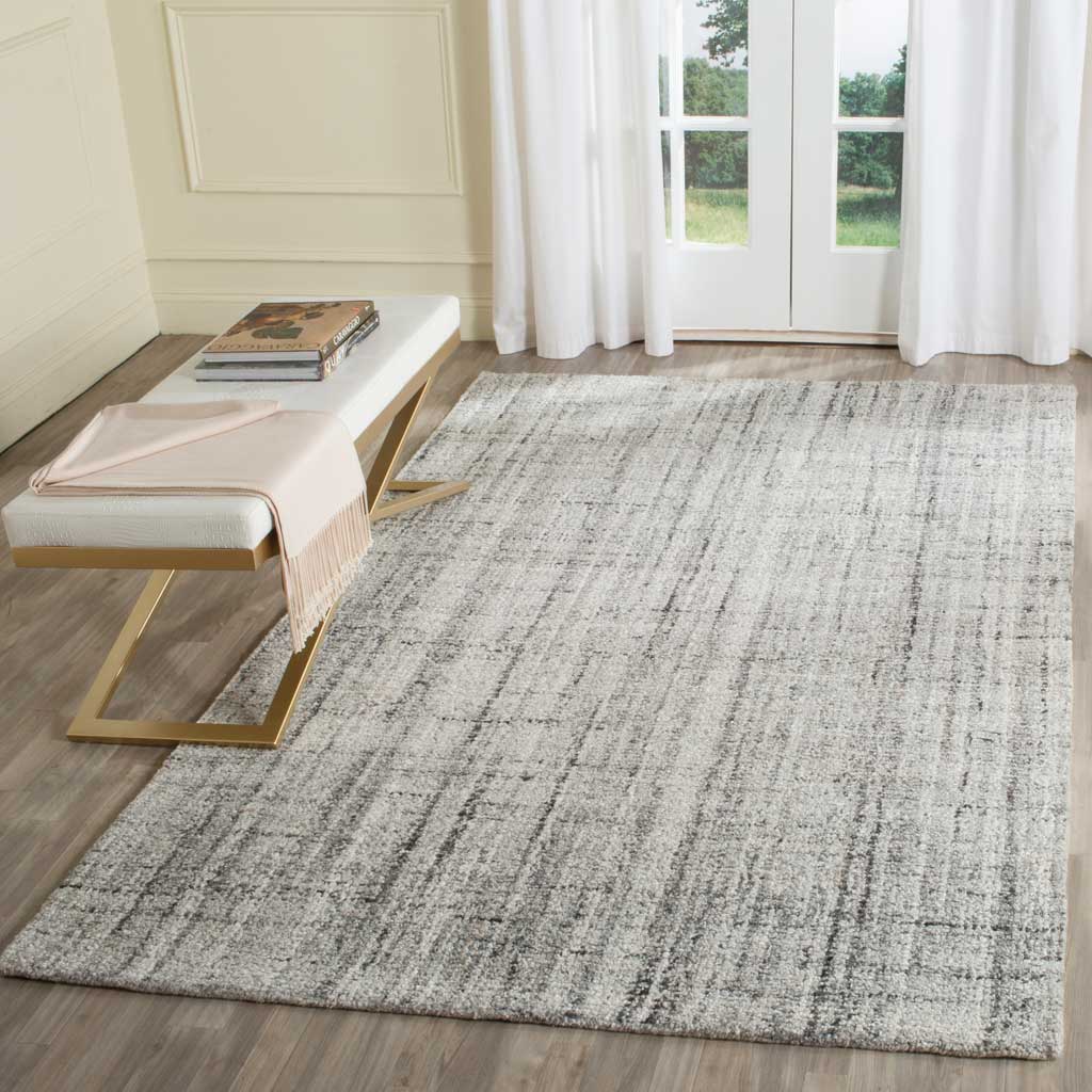 A gray and black rug adds quiet contrast through its irregular grid and gently mottled surface