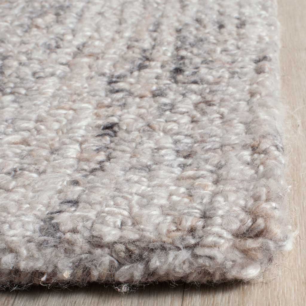 Camel and black tufted fibers create plush texture along a softly finished rug edge