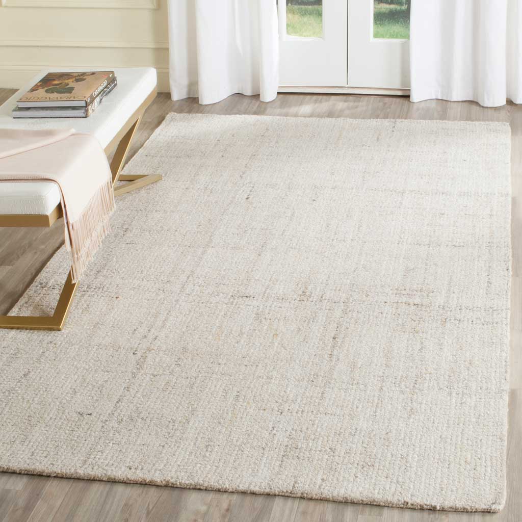 An ivory and beige rug layers subtle linear texture and soft warmth over the floor