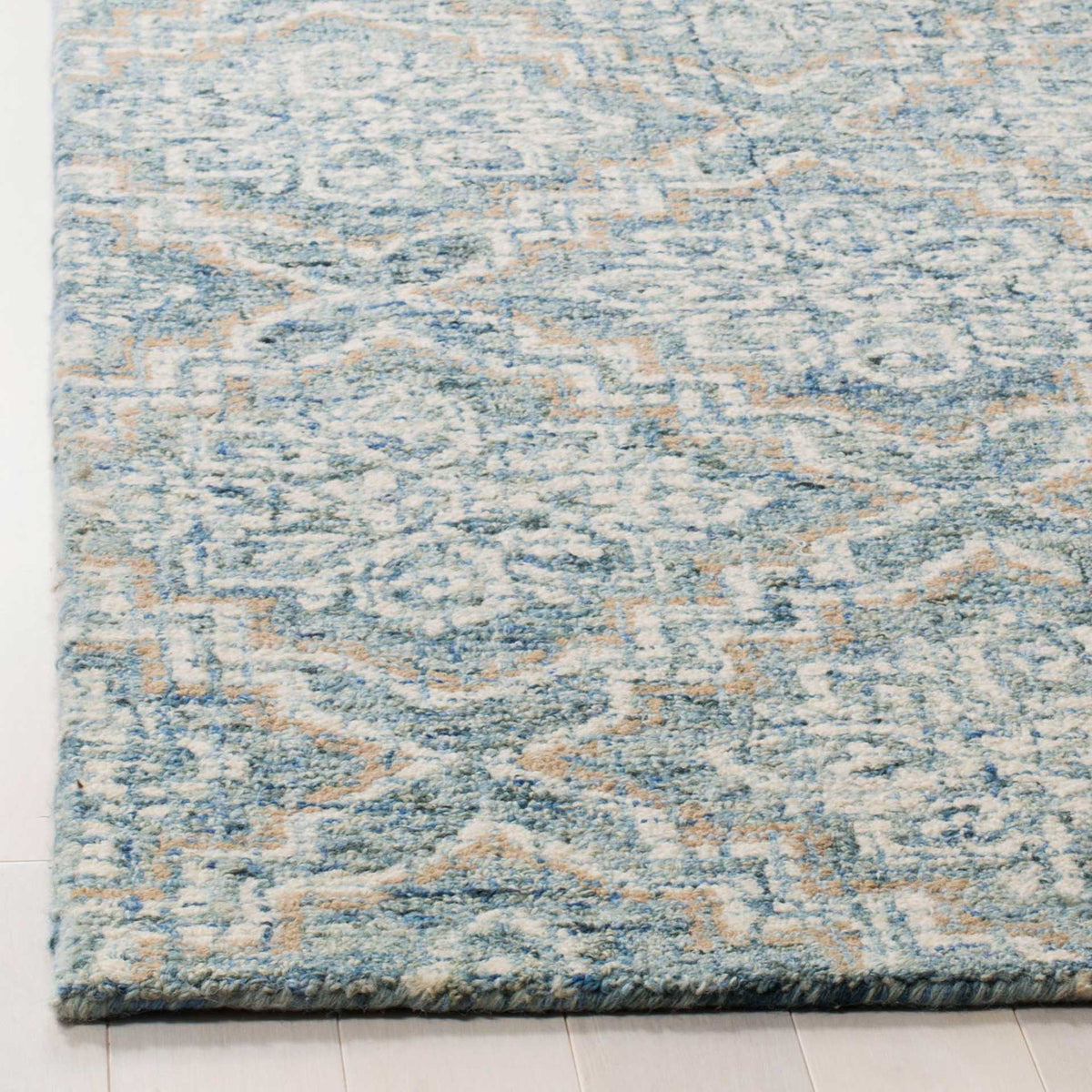 Soft wool pile shows blue and gray floral detailing and a neatly finished rug edge.