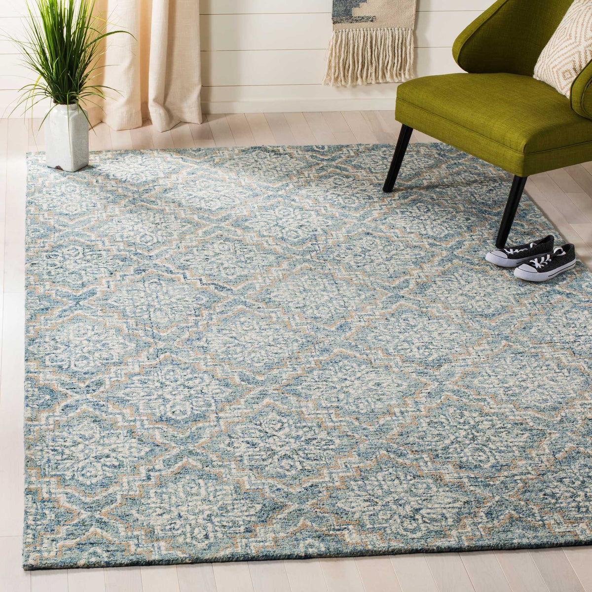 Blue and gray wool rug adds a softly textured floral pattern to a bright seating area.