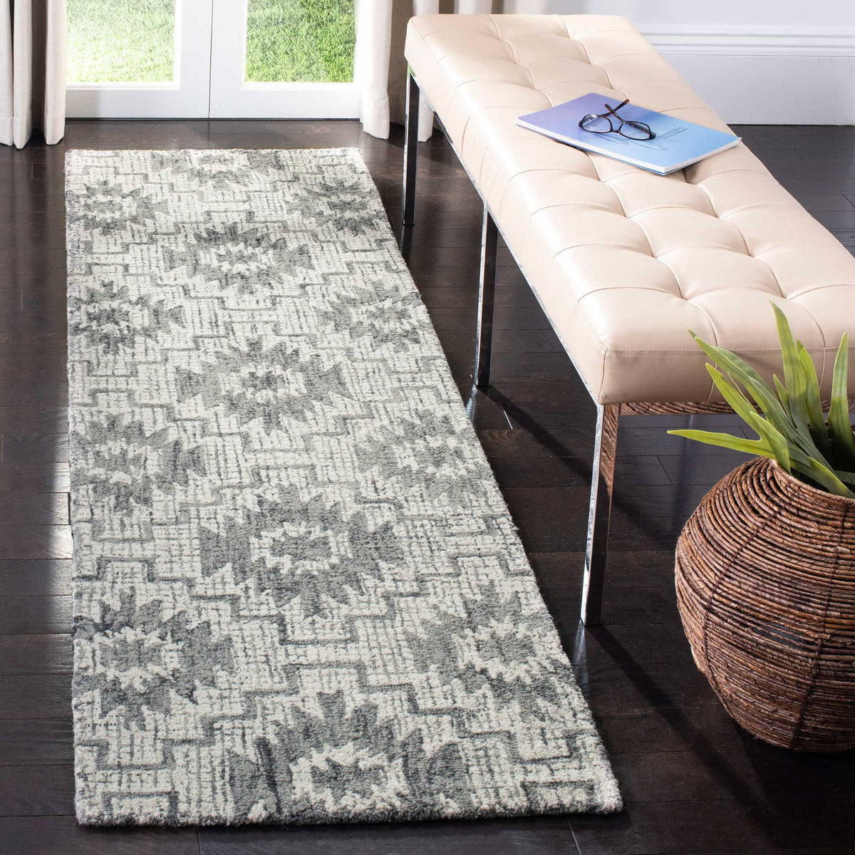 Ivory and dark gray runner adds patterned warmth beside a tufted bench on dark wood flooring