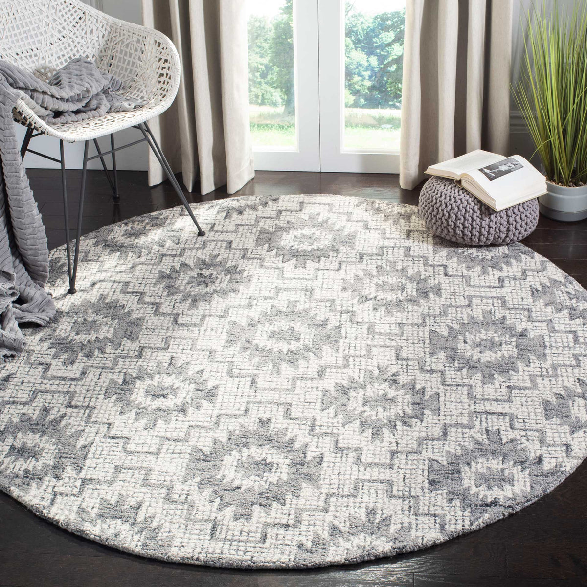 Round wool rug adds a soft ivory and dark gray pattern beneath a cozy lounge chair