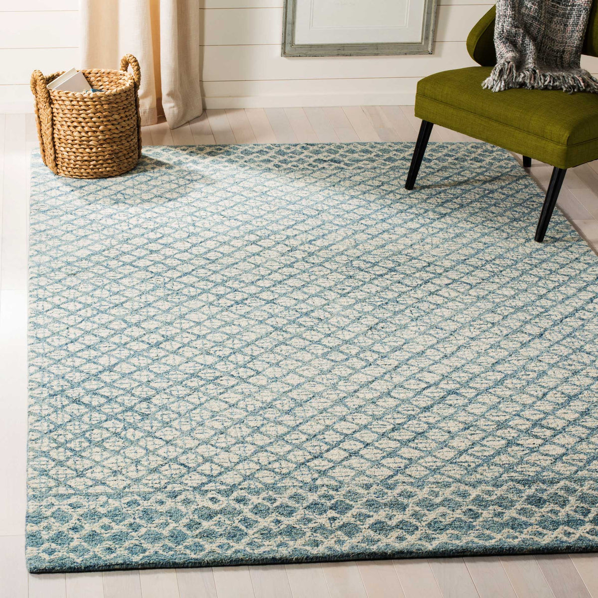 An ivory wool rug layers an airy blue lattice and decorative borders beneath contemporary furnishings.