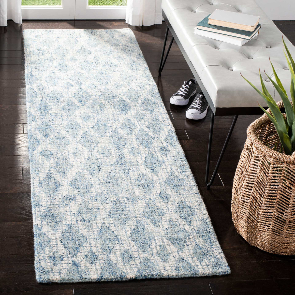 Blue and ivory wool runner adds a soft, vintage-inspired pattern beside a white bench