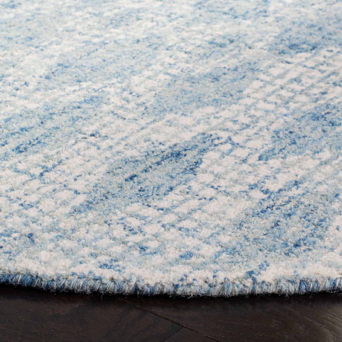 Plush wool pile and a neatly finished edge reveal the rug's soft ivory and blue texture