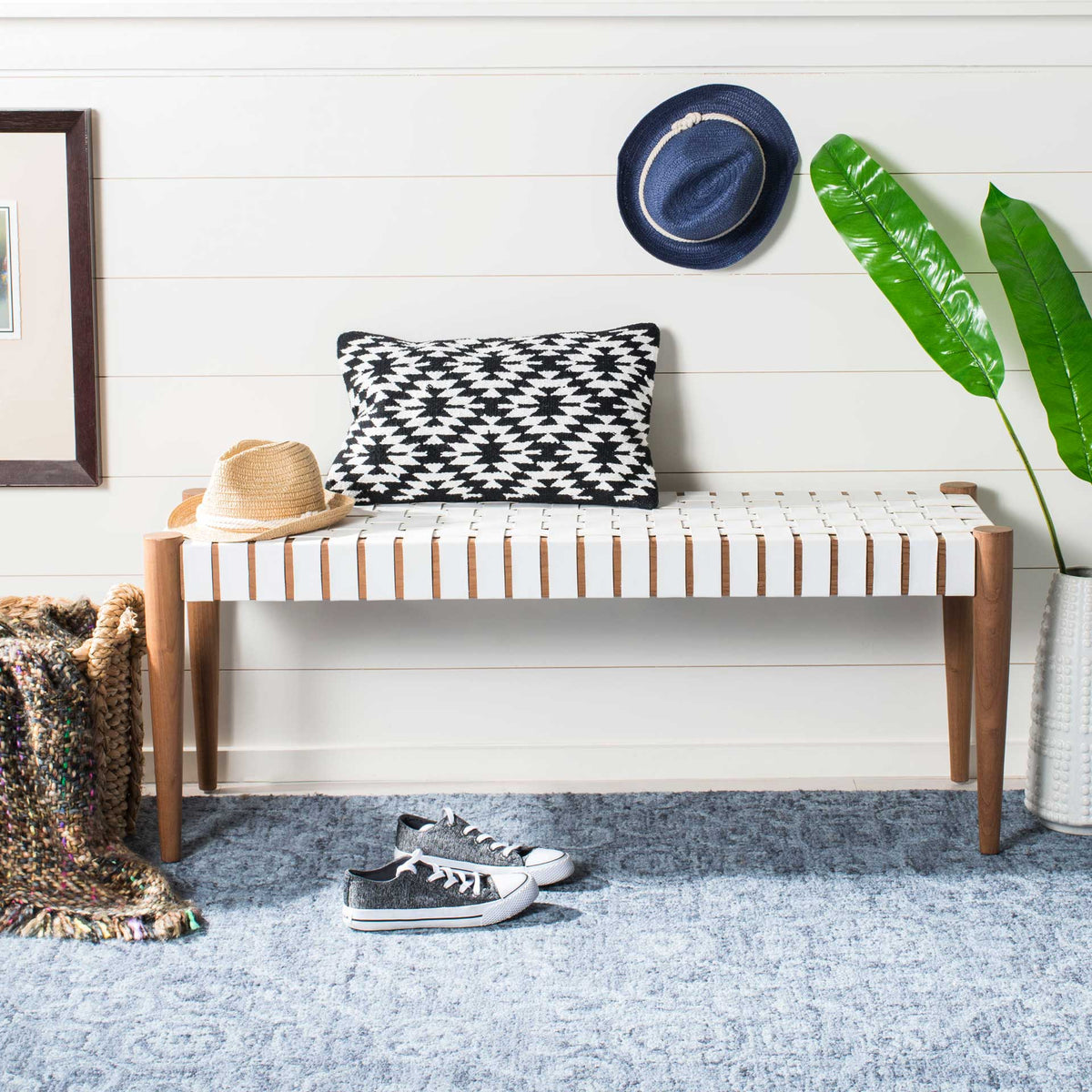 Heathered blue wool rug adds cozy texture beneath a wood-framed bench