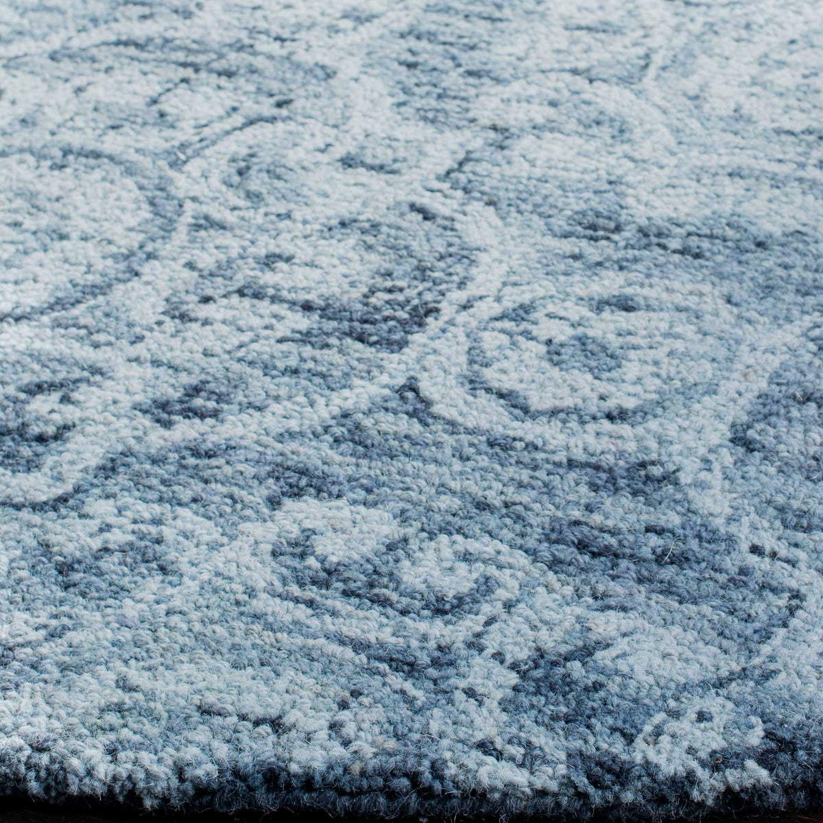 Plush hand-tufted wool pile brings texture to intricate blue patterns