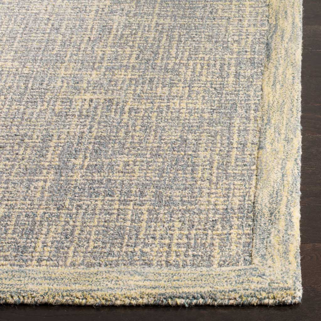 Gold-flecked gray wool pile and a softly raised border give the rug a textured finish.
