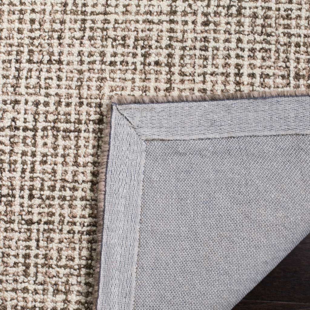 Textured ivory and brown wool pile meets bound edges and woven backing.
