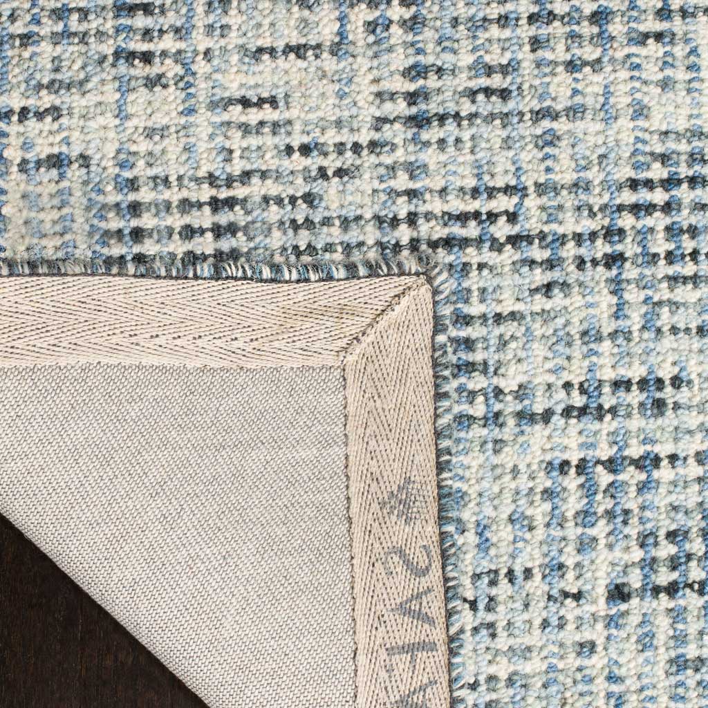 Woven cloth backing and a bound edge finish the blue-and-charcoal wool rug.