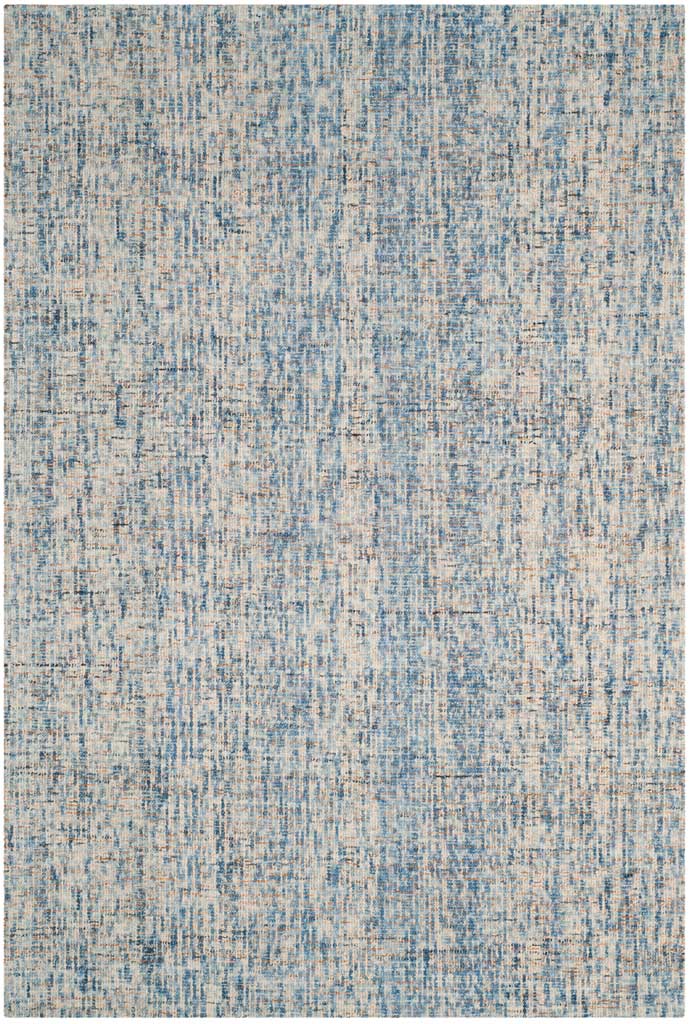 Dense blue markings and warm rust accents enrich the hand-tufted wool rug's pale ground.