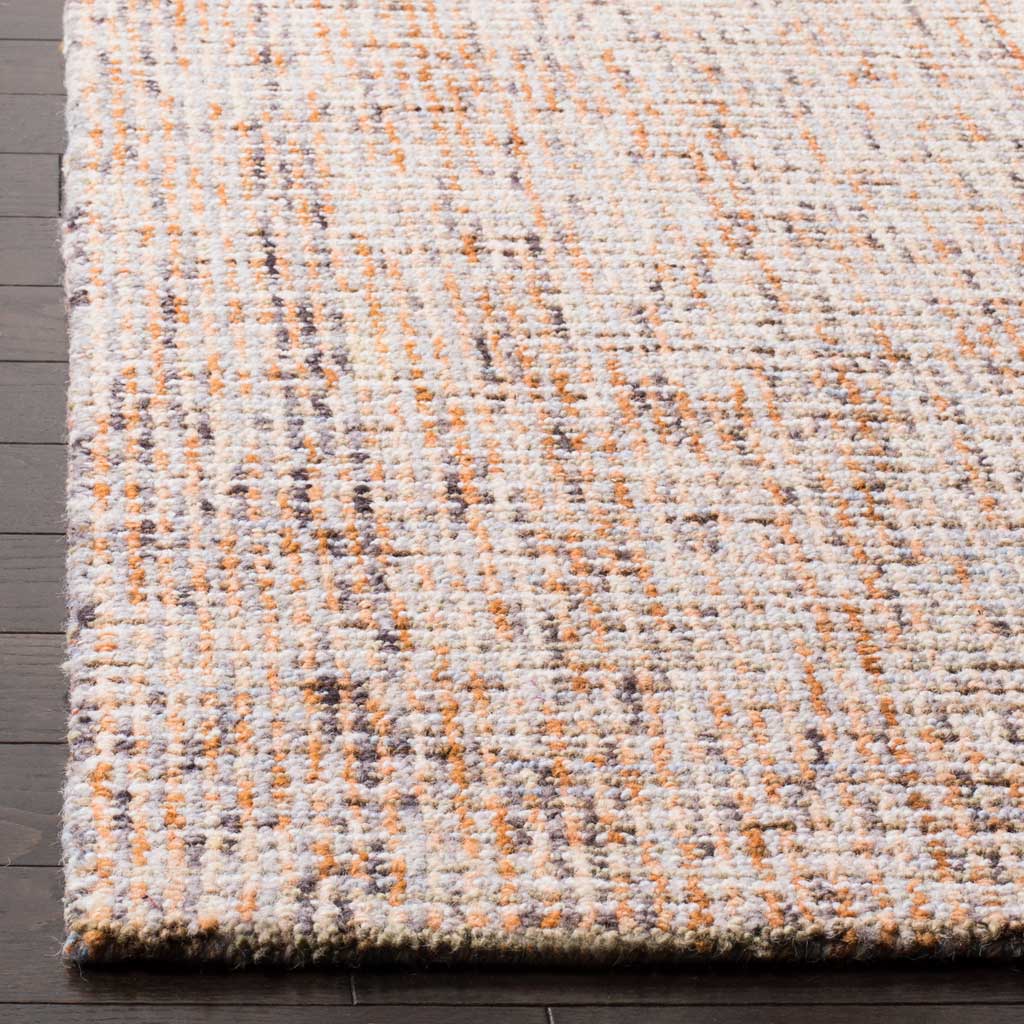 Dense wool fibers and a finished edge accent the rug's mingled gold and blue tones.