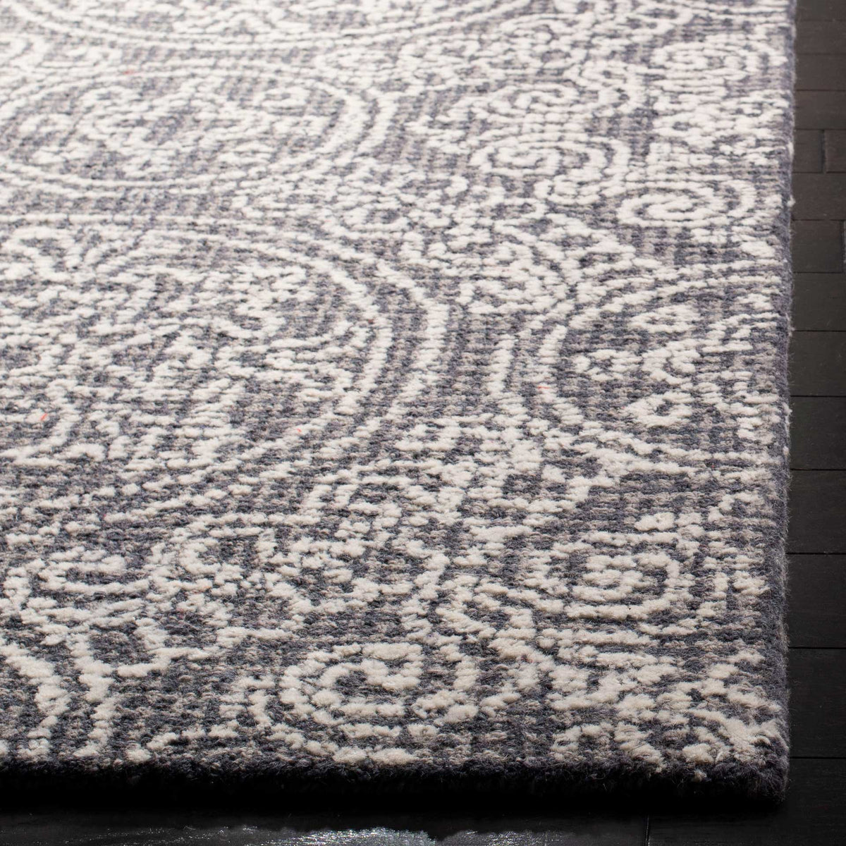 Soft wool pile adds texture to the gray and ivory pattern, finished with a neat rug edge.