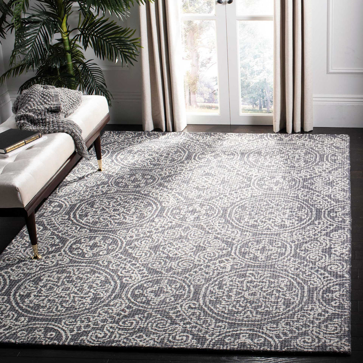 A gray and ivory wool rug anchors a bright living space with medallions and intricate scrollwork.