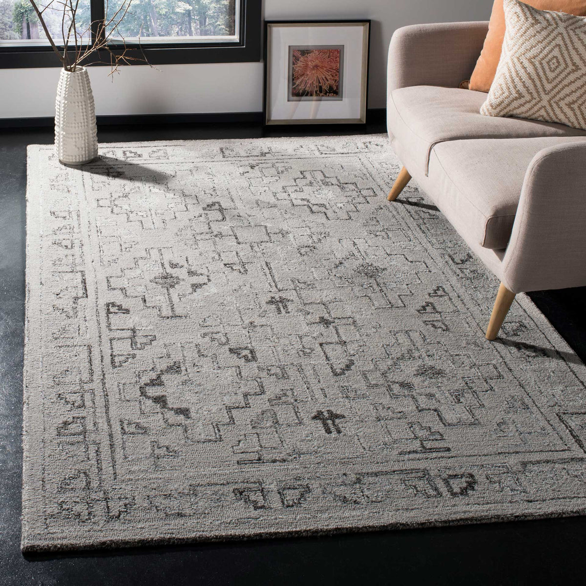 Taupe and black geometric rug adds soft texture and a patterned border to a living room