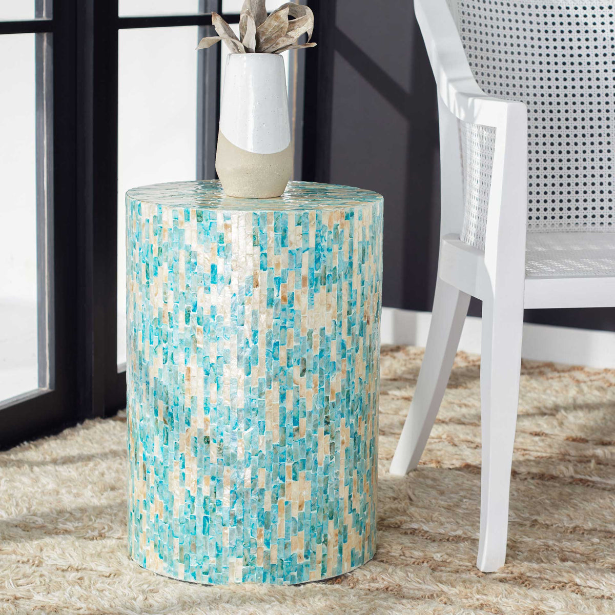 A blue and gold mosaic accent table brightens a seating area and holds a decorative vase