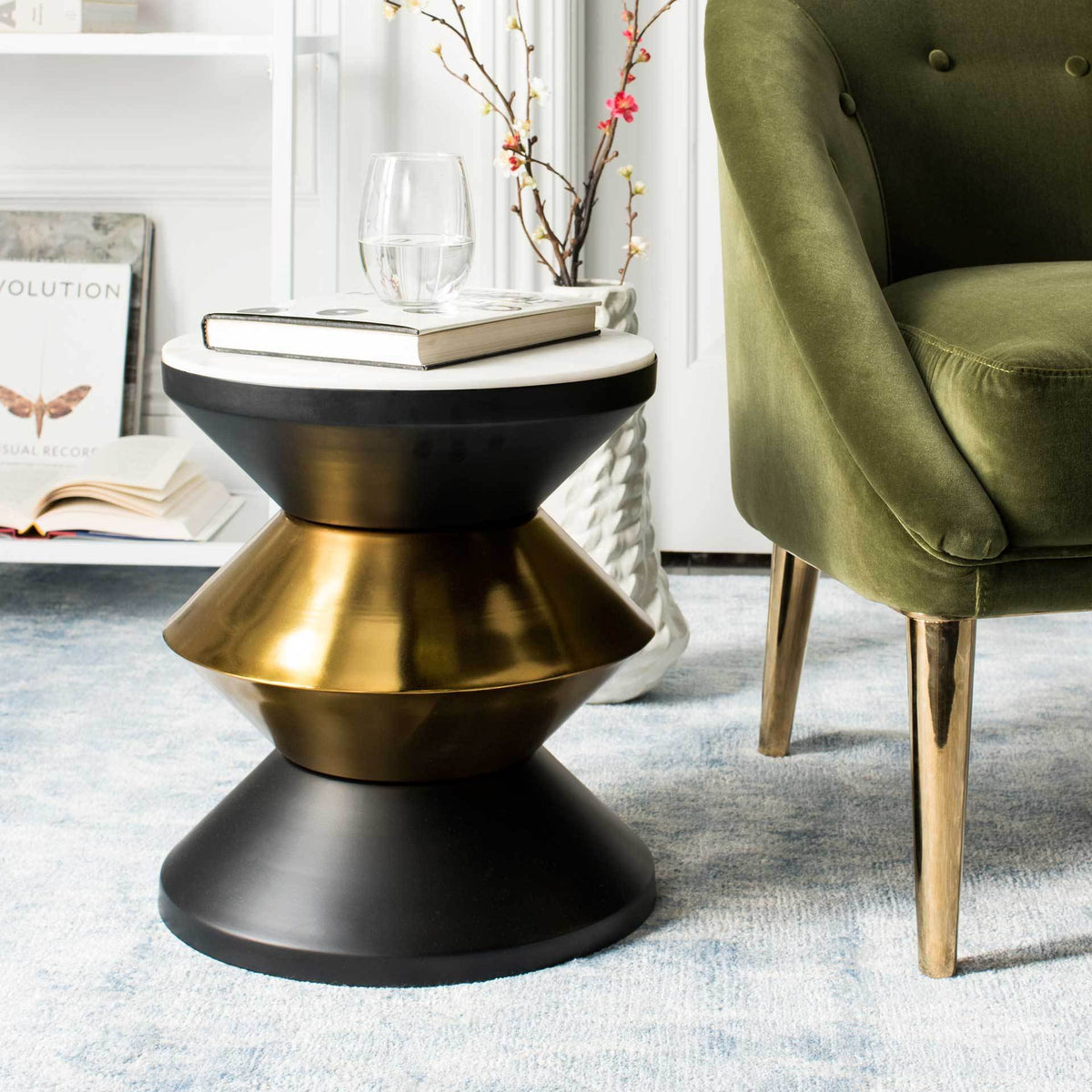 Gleaming gold tiers add warmth to the black base beneath a white stone tabletop
