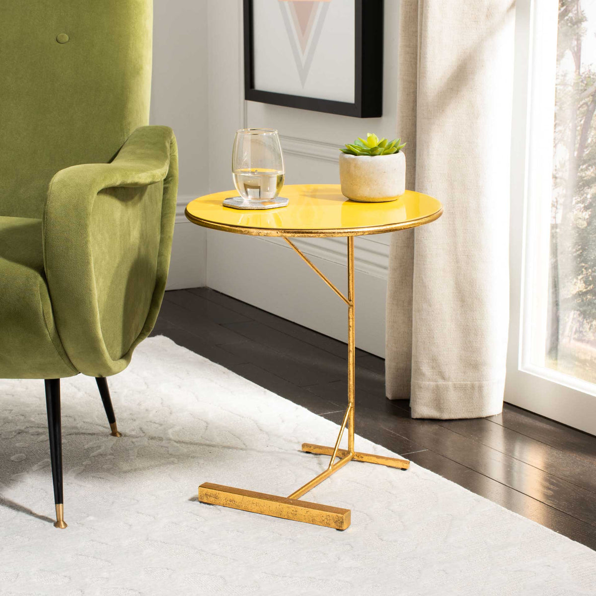 A bright yellow tabletop on an airy gold base keeps a drink and plant beside a chair.