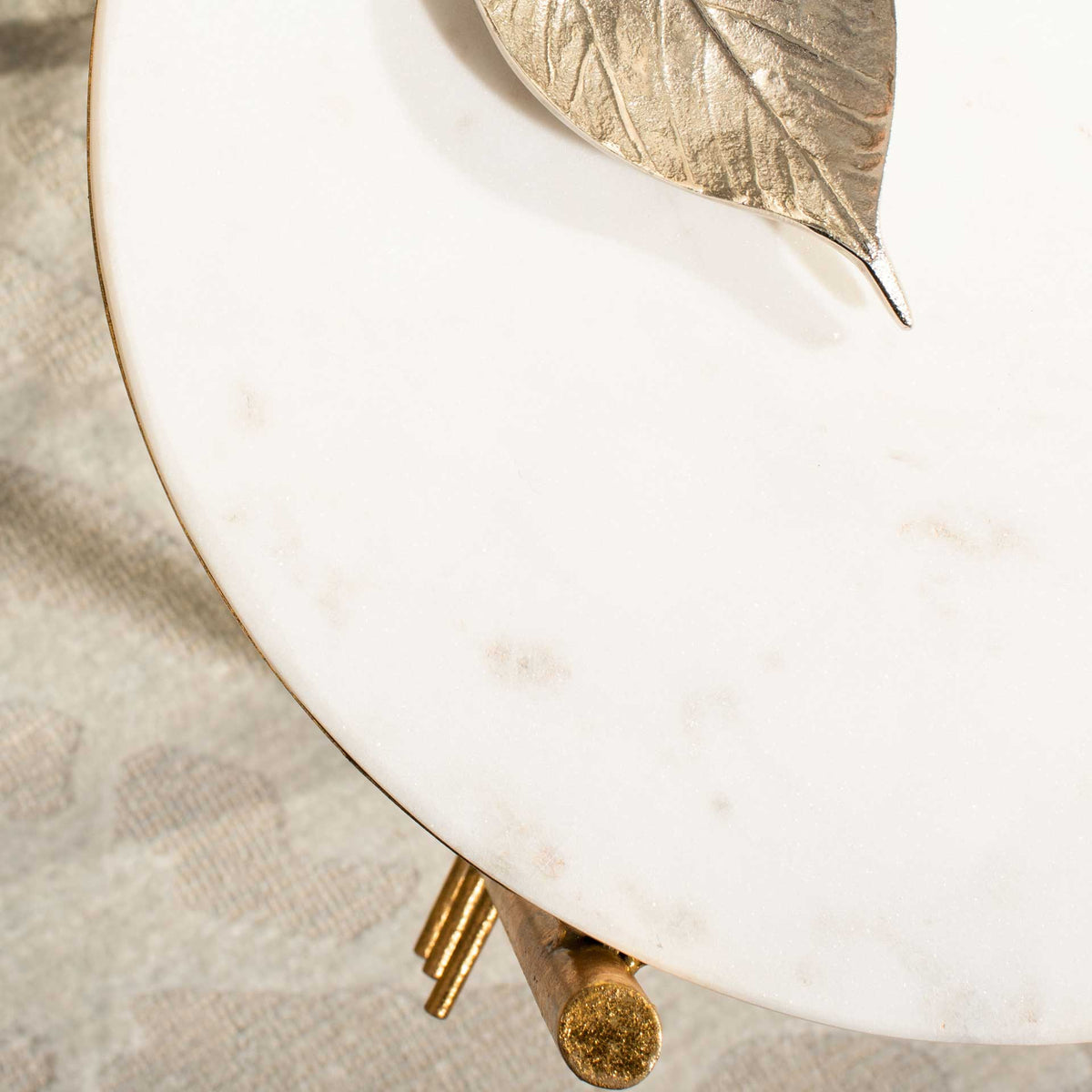 Soft natural veining gives the white marble top a refined surface above the gold frame.