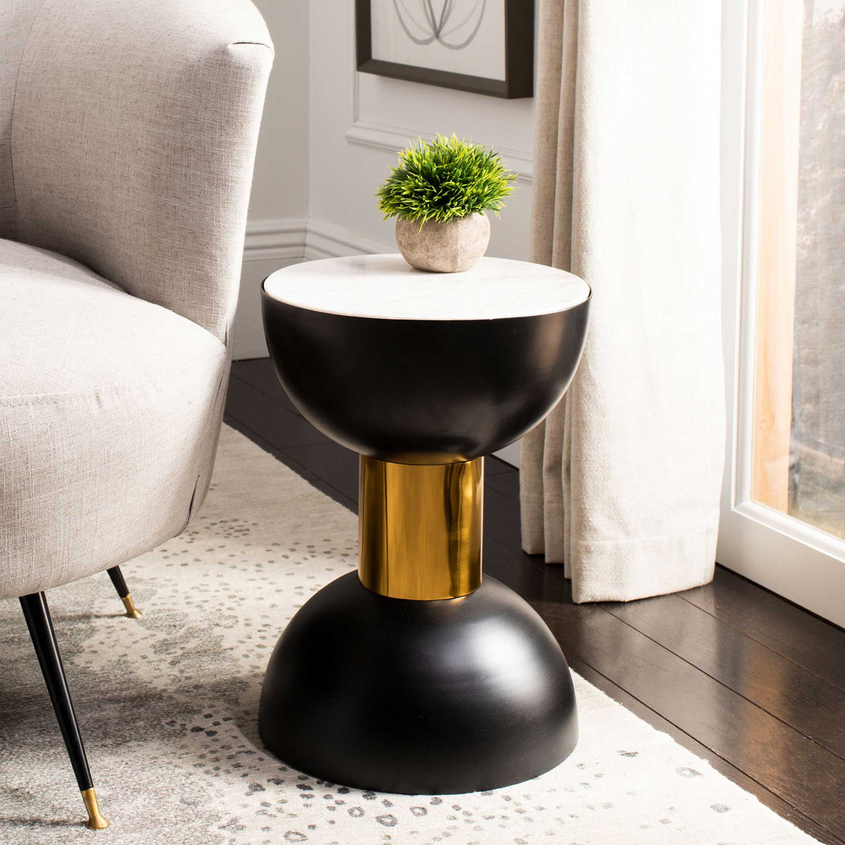 White marble top, curved black base and gold center complement a cozy seating area