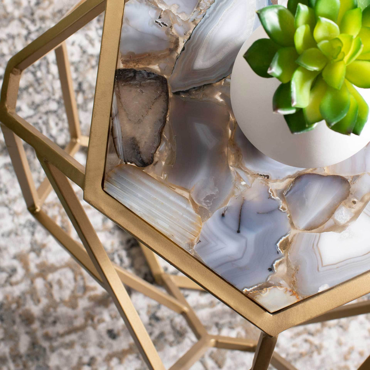 Natural agate banding and warm gold trim give the tabletop its distinctive texture.