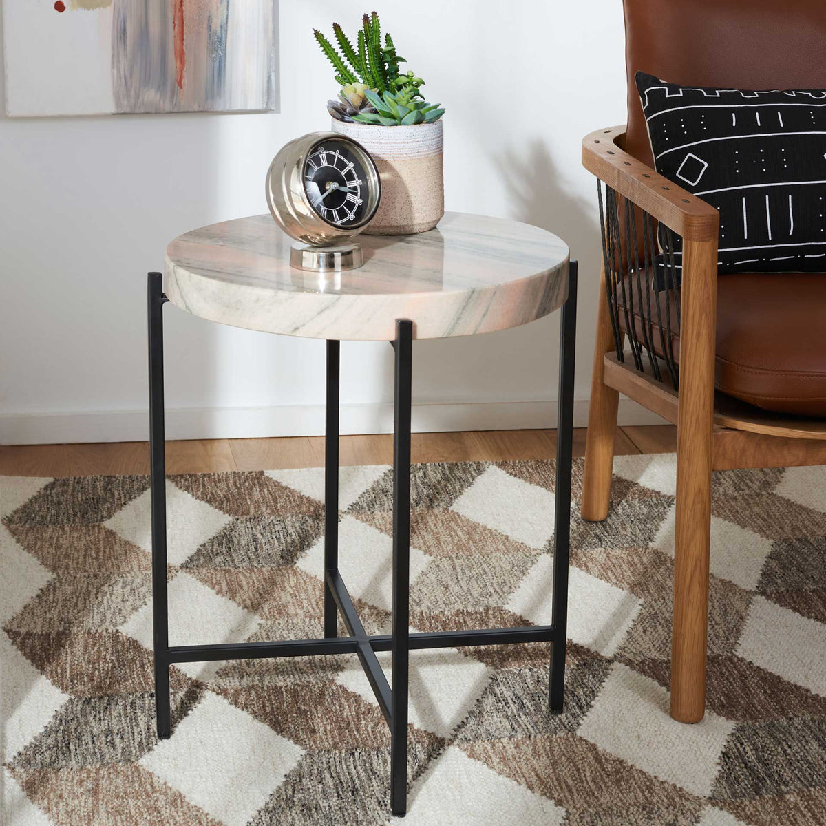 A round marble top and slender black metal base bring understated contrast to a cozy seating area