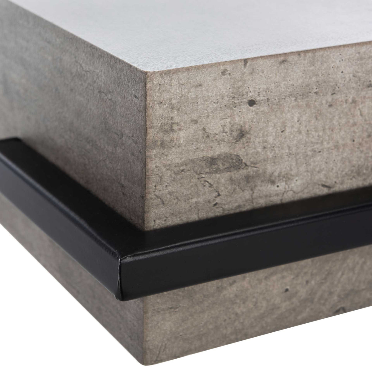 A thick gray tabletop meets crisp black iron framing along its squared corner.
