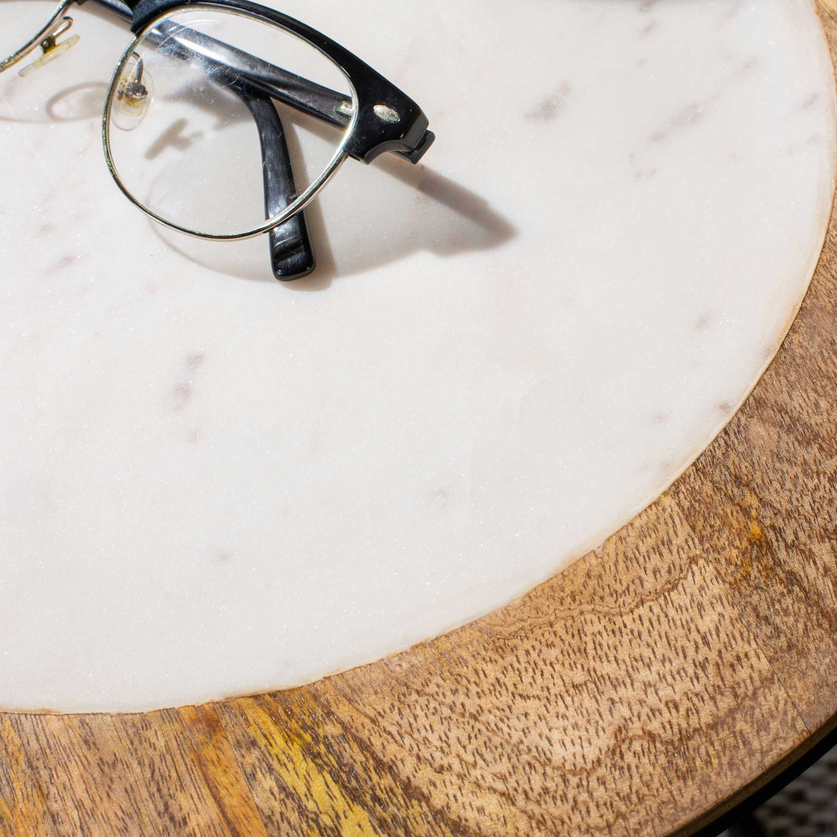 Subtle veining in the white marble contrasts with the wood rim's richly varied grain