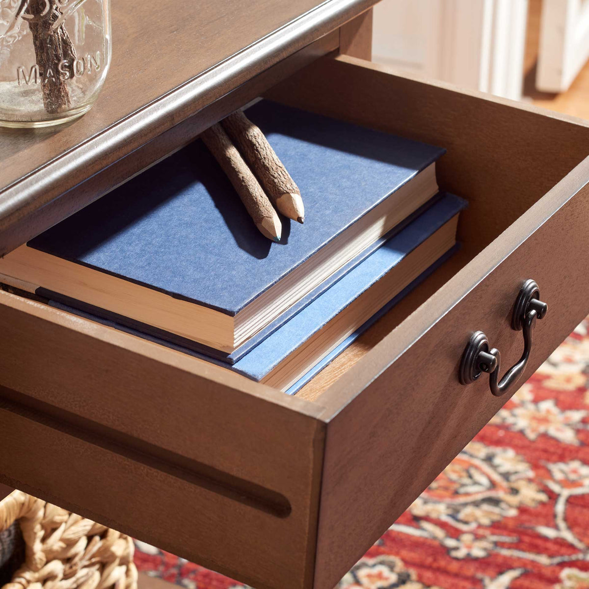 An open brown drawer keeps books and pencils organized under the tabletop
