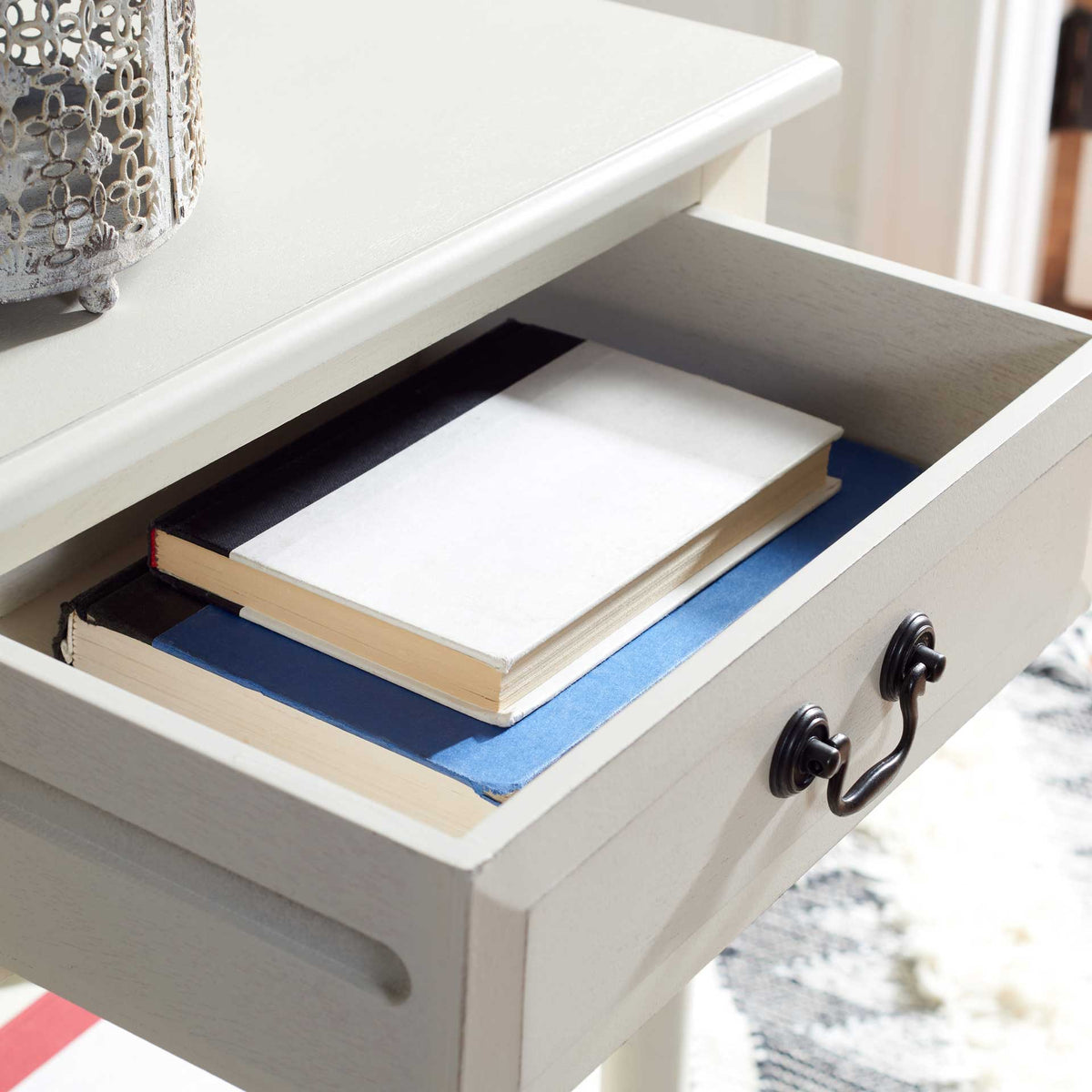 Roomy white drawer keeps books tucked away under the smooth tabletop