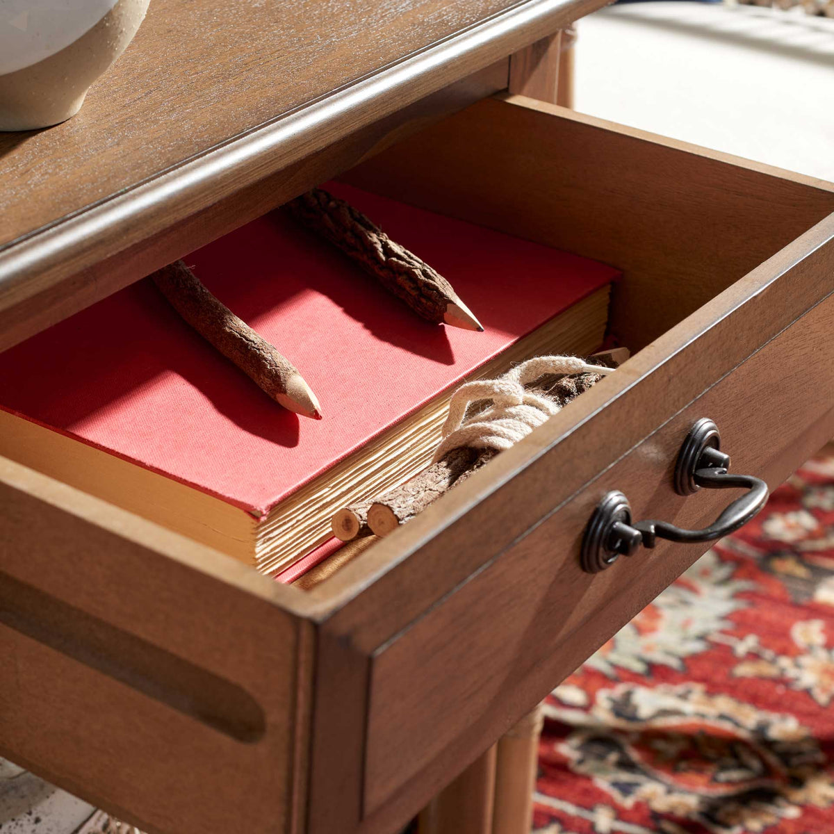Open brown drawer offers space for books and everyday essentials beneath the tabletop