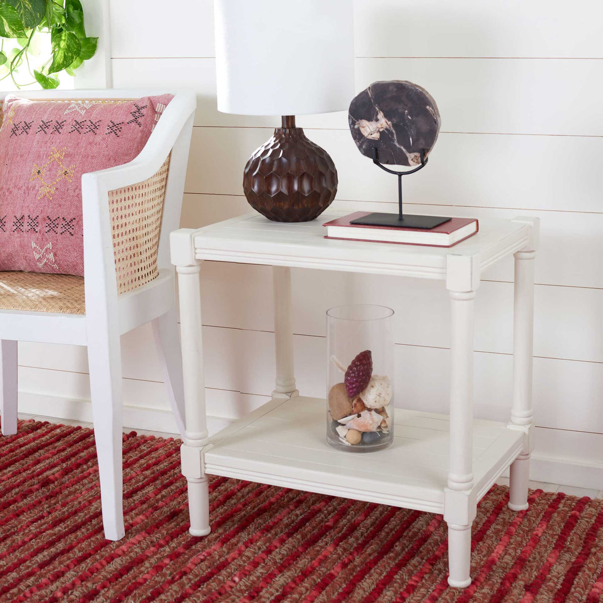 Distressed white accent table with a lamp on top and a lower shelf for decorative accents